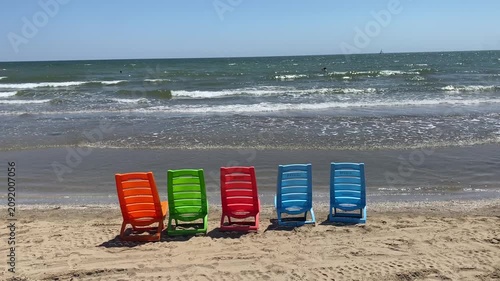 serie di sedie in plastica colorata in riva al mare