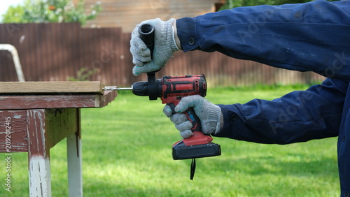 Foto Builder worker using cordless hammer drill