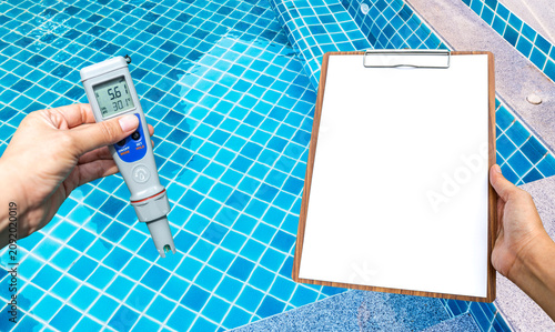Foto Swimming pool water testing test kit with blank report paper on wooden clipboard