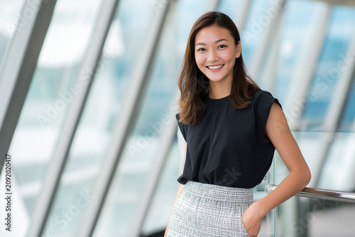 Young attractive Asian corporate manager, elegant skirt, executive brainstorming workshop, inspired employees, leadership impact, premium office portrait.