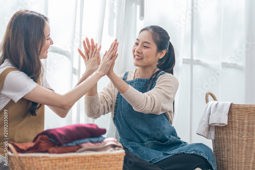 Quadro su tela Asian woman, laundry, basket, clothing, high five, friendship, smiling pair fold