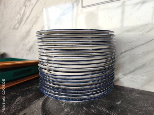 stack of blue floral patterned plates on a dark marble countertop in a kitchen.
