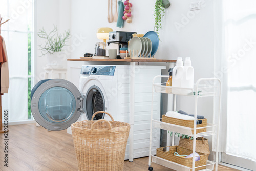 Laundry room washing machine dryer basket detergent shelf clean white home interior with organized appliance dish and storage cart near bright window