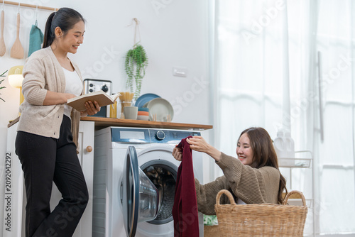Woman laundry washing machine basket clothing home household clean fabric indoor, smiling women doing laundry home with front load washer, wicker basket, red garment, bright domestic room