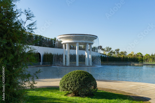 Lake of Love and the Rotunda Fountain in public landscape city Park Krasnodar or Galitsky Park. Modern circular water fountain with cascading streams, surrounded by shallow pool