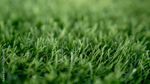 High-quality macro shot of lush green artificial grass or synthetic turf texture, vibrant color and realistic detail, perfect background for eco-friendly concepts, sports, garden, or spring season int