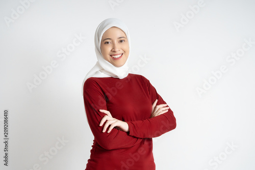 Smiling Confident Muslim Woman Wearing White Hijab and Red Sweater With Arms Crossed