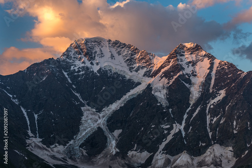 фотографія Sunset Light on Snow-Capped Twin Peaks with Glaciers, Altai Mountains, Siberia,