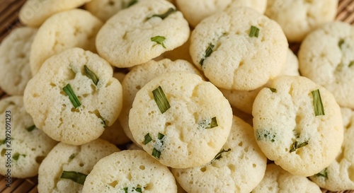 Crispy Round Rice Crackers with Green Herb Pieces in Close Up Food Background
