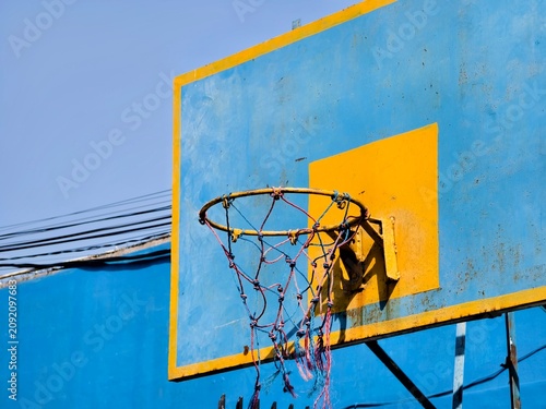 Foto Weathered Blue Basketball Backboard with Yellow Square and Rusty Hoop