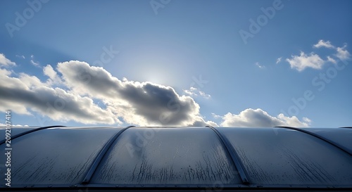 Curved Modern Glass Roof Under Bright Cloudy Blue Sky