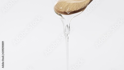 Transparent hyaluronic acid slowly flows, moisturizing lotion close-up.