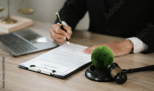 Judge signing legal documents beside a green Earth and gavel, symbolizing environmental law, ESG compliance, and climate governance.