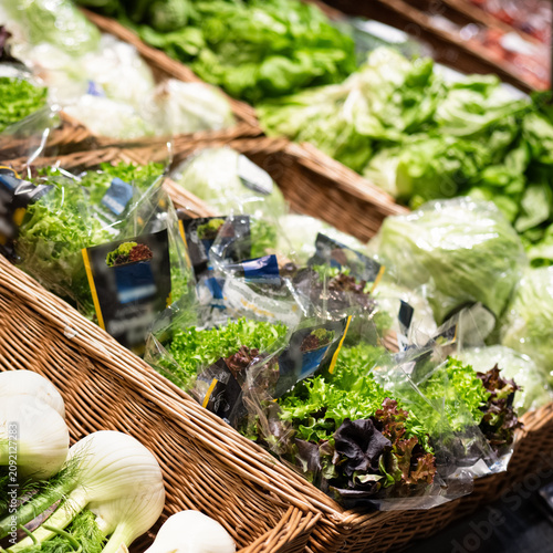 Foto Packaged fresh lettuce in supermarket retail display grocery food shopping conce