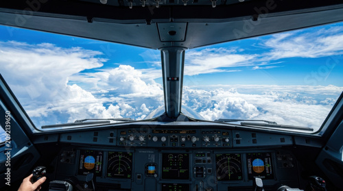 Aircraft cockpit pilot view flight deck airplane interior instrument panel cloudscape Blue sky visible through aircraft cockpit window from pilot view, flight deck with instrument panel