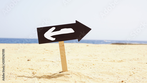 Cuadro en lienzo Change to Opposite Direction Sign on Sandy Beach Symbolizing Business Decision,