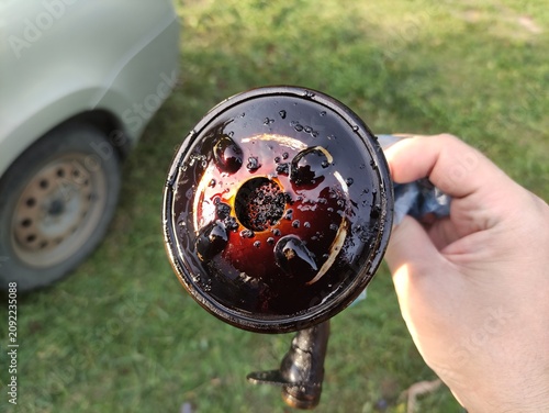 Canvas Print Close up of dirty engine oil strainer with sludge and bubbles held in hand