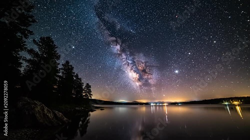 Night sky reflection with stars over water and silhouette trees