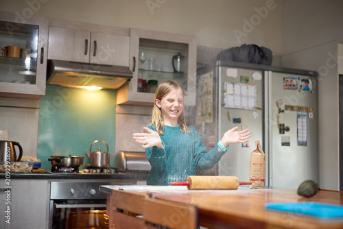 Young girl and grandmother baking together in a cozy kitchen with flour and rolling pin