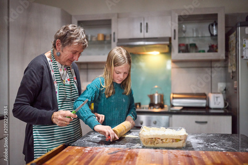 Grandmother and granddaughter baking together in a cozy home kitchen
