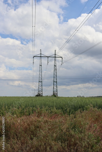 High voltage power lines over green agricultural field
