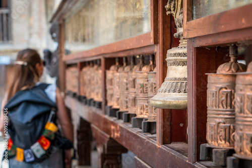 Фотография Mujer rodando los rodillos de plegarias en un templo budista en la ciudad de Katmandú, en Nepal