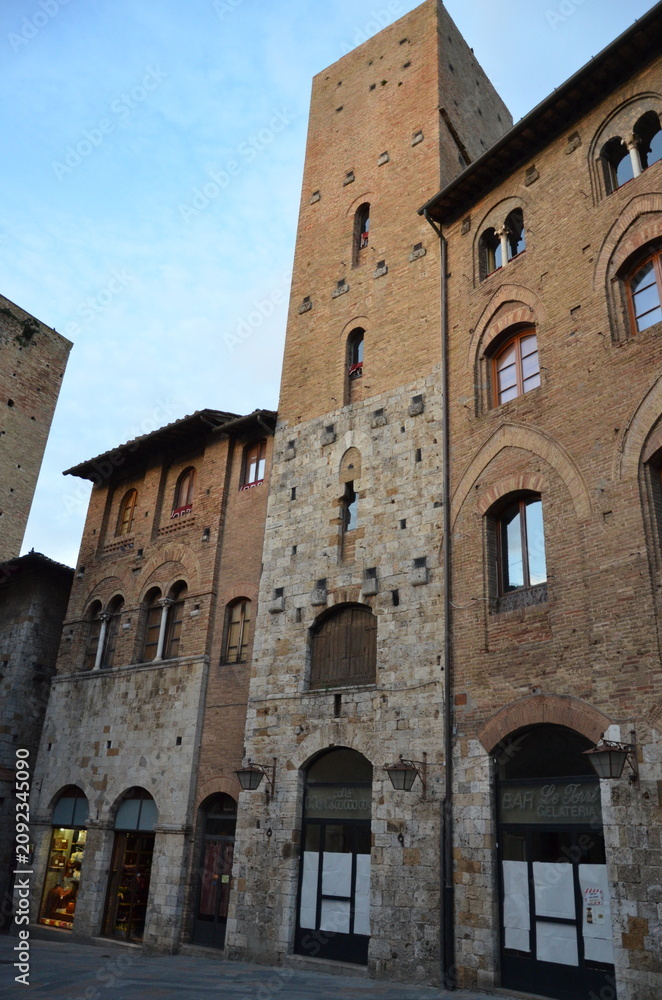 Obraz premium San Gimignano, Italy 03.04.2020: Town Hall (also known as the Palazzo del Popolo or Palazzo Nuovo del Podestà) and the Torre Grossa in San Gimignano
