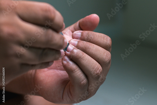 man hands maintaining hygiene by trimming nails at home as part of a self-care routine.