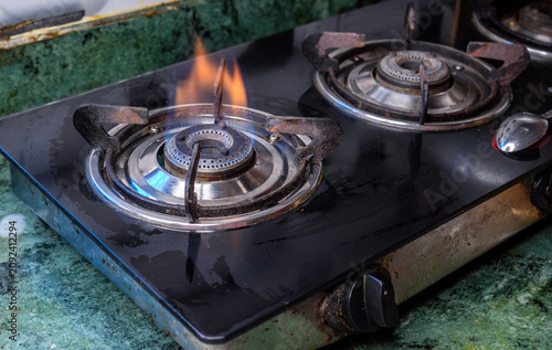 Home kitchen gas oven - orange tongues of blue flame of a gas burner. Horizontal banner with burning gas stove burner on the kitchen stove. cooking concept.