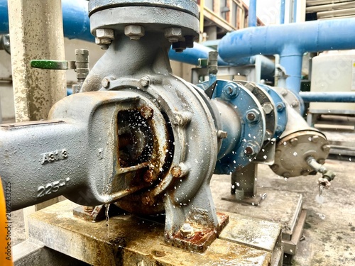 Obraz na plátně Close-up of a damaged centrifugal water pump with leaking seal and splashing water in an industrial plant, illustrating equipment failure, maintenance, repair, reliability and mechanical engineering