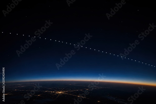Starlink satellites forming a trail in the night sky above Earth's horizon, showcasing space technology.