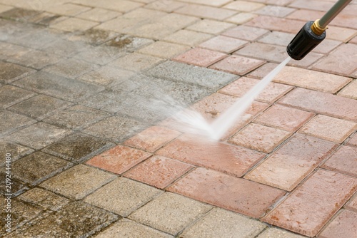The Pressure Washer Cleaning Bricks With High Powered Water Jet On Pavement
