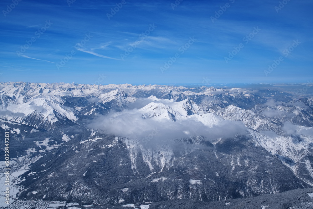 Fototapeta premium Stunning winter panoramic view of alpine mountain ranges above the clouds.