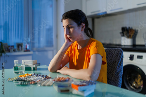 Stressed Woman Struggling With Night Medication Dose At Home Table