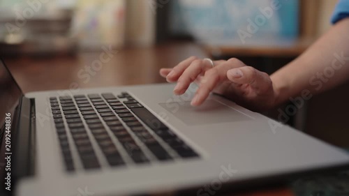 Close up view of a hand scrolling and using gestures on a laptop's trackpad with a shallow depth of field, Close-up view of a woman's hand using the touchpad on a laptop computer. tapping, scrolling.