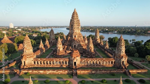 Ancient buddhist temple complex with stone towers near the river at sunset in Ayutthaya