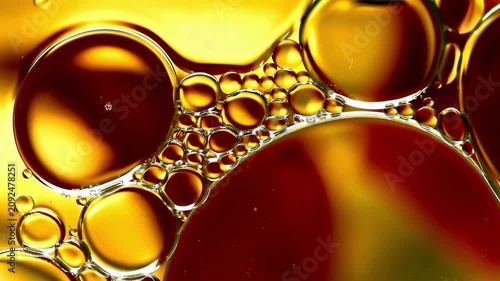 Macro Science. Oil bubbles floating, chemical reaction, slow motion footage, abstract golden liquid texture for scientific background.
