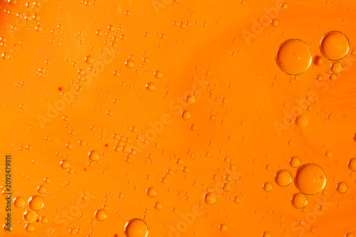 Abstract orange liquid background with floating oil bubbles