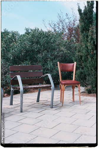 an old leather chair left beside a park bench,  35mm film