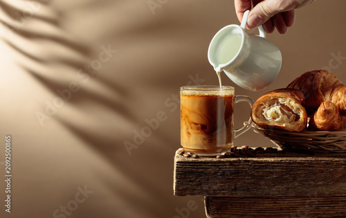 Coffee latte with croissants on an old wooden table.