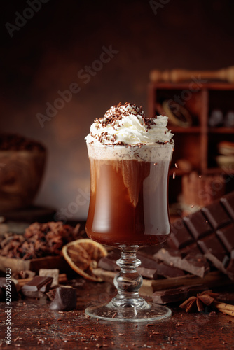 Hot chocolate topped with whipped cream and sprinkled with chocolate chips.