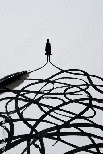 Minimalist ink illustration of a woman silhouette standing at the destination of a tangled messy path, symbolizing clarity, mindfulness, psychotherapy, and overcoming anxiety. Black and white, pen ink