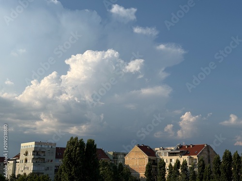 Dramatic Cumulus Clouds Towering Over City Rooftops and Apartment Buildings