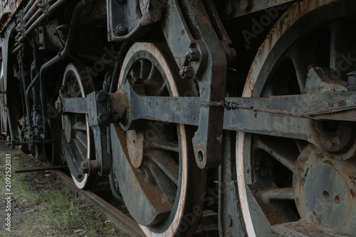 Photography Close up of rusty driving wheels and steel rod linkage on vintage steam locomoti