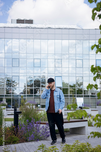 Businessman talking on smartphone during outdoor work break, copy space.