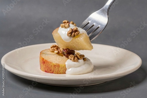 Tufahija on plate, poached apples stuffed with walnuts cream highlighted by yogurt drizzle and walnuts. Concept of dessert, elegance, sweetness, flavors, culinary delights.