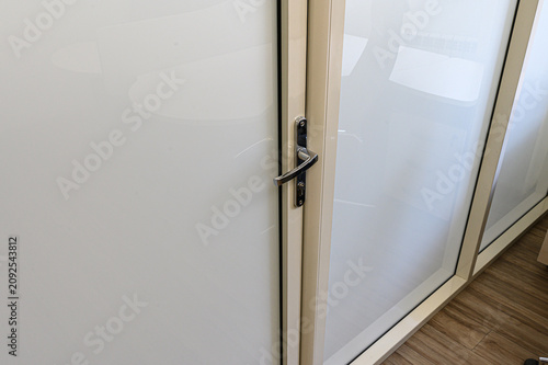 Fotografie modern interior door features frosted glass panels, beige aluminum frame, sleek