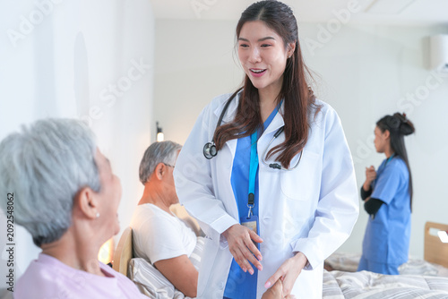 Fényképezés Senior care scene: Elderly Asian friends gather to chat and laugh together near