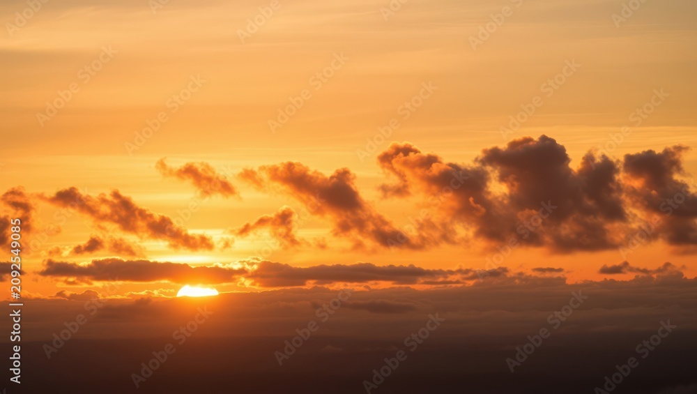 Fototapeta premium Beautiful orange sunset sky with clouds and bright sun