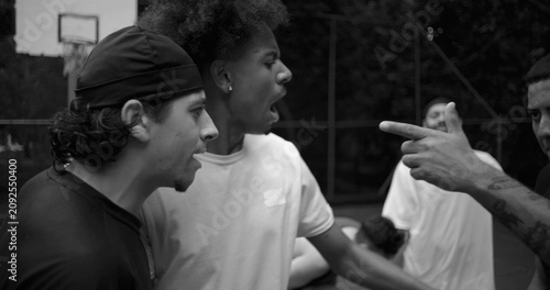 Canvastavla Heated argument between two men of Latin and African descent on outdoor basketba